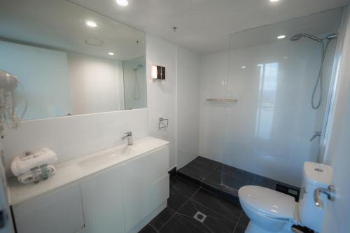 een badkamer met een wastafel, een toilet en een spiegel bij Chevron Renaissance - Resort Style Living by Gold Coast Premium in Gold Coast