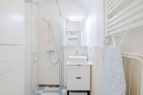 ein weißes Bad mit einem Waschbecken und einer Dusche in der Unterkunft Modern apartment in City Centre in Danzig