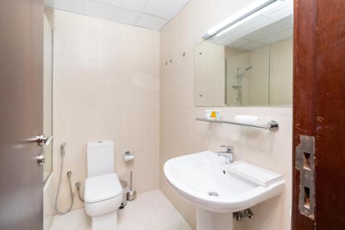 a bathroom with a sink and a toilet and a mirror at Amazing Studio with Balcony & Beach access-RAK in Ras al Khaimah