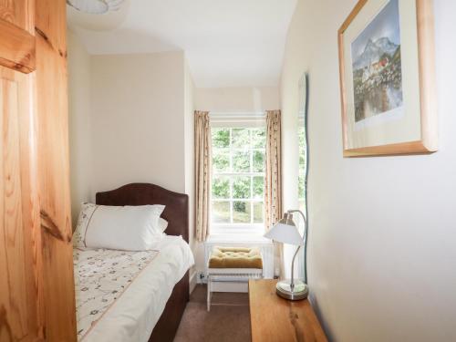 a small bedroom with a bed and a window at Ty Nain in Caernarfon