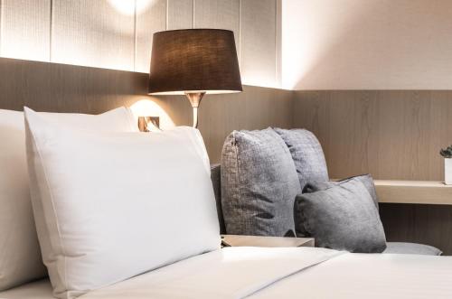 a bedroom with a laptop on a bed with a chair at Hotel Valletta in Jiaoxi