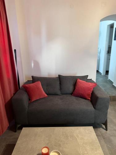 a couch with two red pillows in a living room at Maistros Villas in Armenistis