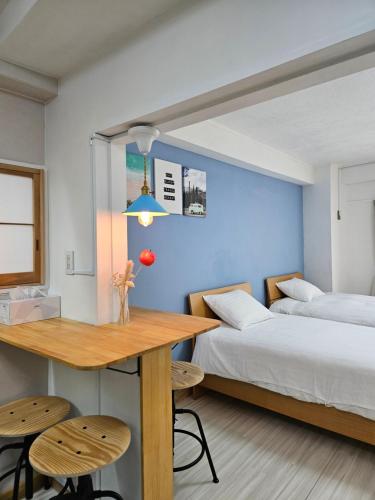 a bedroom with two beds and a table and chairs at STAY ARI Kabukicho in Tokyo