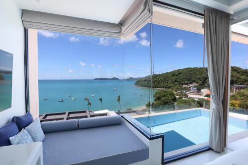 a bedroom with a view of the ocean at Bandara Pool Villas, Phuket in Panwa Beach