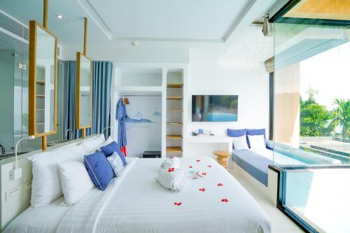 a bedroom with a large white bed with flowers on it at Bandara Pool Villas, Phuket in Panwa Beach
