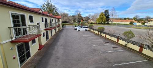 a car parked in a parking lot next to a building at New Castle Motor Lodge in Rotorua