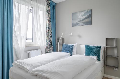two beds in a bedroom with a window at RentPlanet - Port Popowice in Wrocław