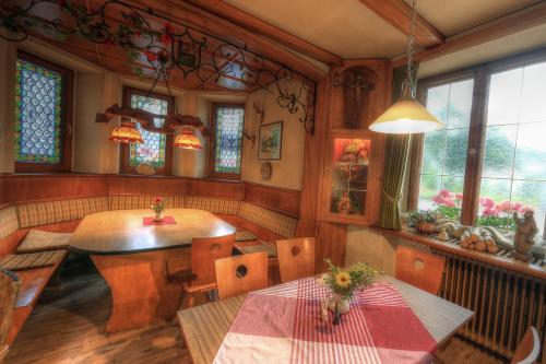 a dining room with a table and chairs and windows at Lenzkircher Hof in Lenzkirch
