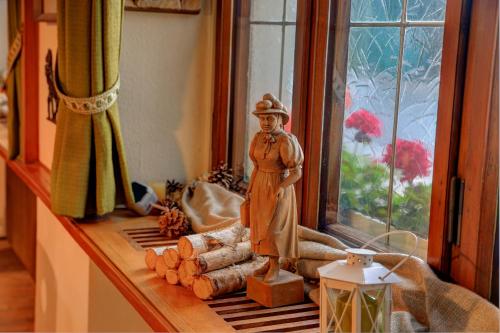 a statue of a man in a hat sitting on a window sill at Lenzkircher Hof in Lenzkirch