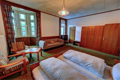 uma sala de estar com uma cama e um sofá em Lenzkircher Hof em Lenzkirch