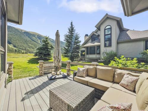 a patio with a couch and an umbrella and a house at Woods25 Townhome Condo in Copper Mountain