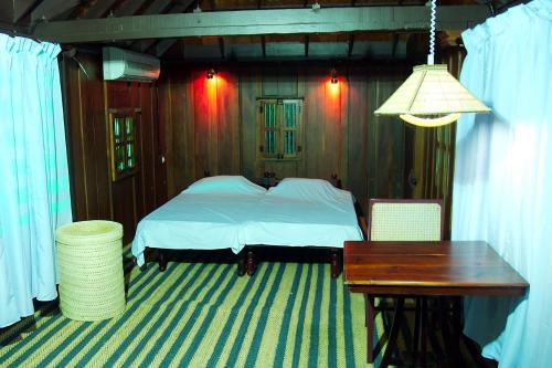 a bedroom with a bed and a desk and a table at Elephant Courtyard- A Heritage Homestay in Alleppey