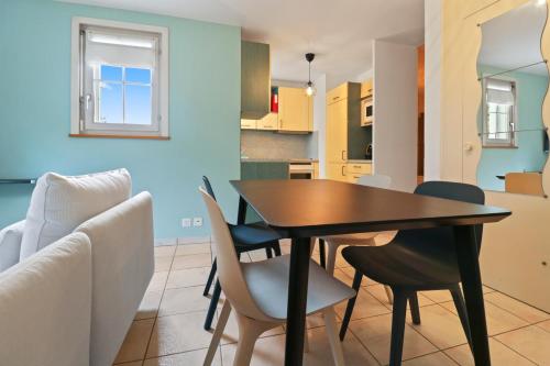 a dining room and kitchen with a table and chairs at Appartement paisible avec terrasse in Domdidier