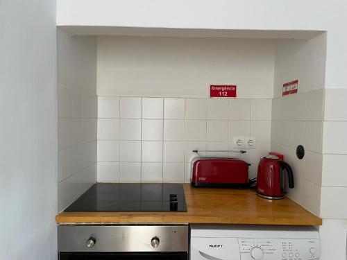 - une cuisine équipée d'une cuisinière et d'un appareil rouge dans l'établissement Casa do Cristo Rei II, à Almada
