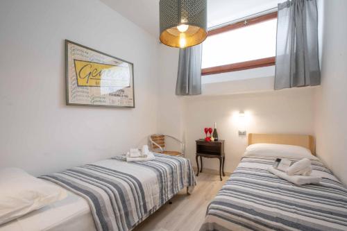 um quarto com 2 camas individuais e uma janela em Casa Angerin 2 - 100m from sea- Happy Rentals em Alassio