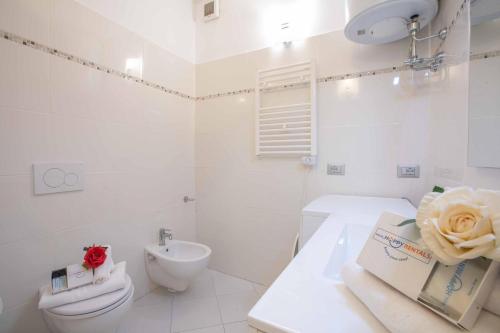 uma casa de banho branca com um WC e um lavatório em Casa Angerin 2 - 100m from sea- Happy Rentals em Alassio