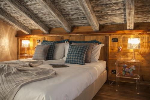 sypialnia z dużym białym łóżkiem i drewnianymi ścianami w obiekcie Le Parfum du Sel w Aoście
