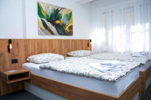 a bedroom with a large bed with a wooden headboard at Apartman City Peace Sarajevo, 72 m2, free parking in Sarajevo