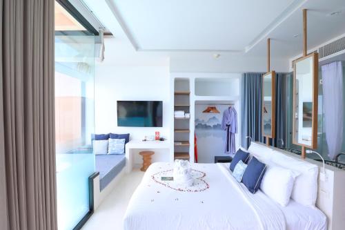 a bedroom with a white bed and a large window at Bandara Pool Villas, Phuket in Panwa Beach