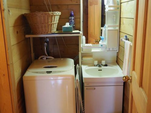 a small bathroom with a washing machine and a sink at GlampHouse DAISEN Forest - Vacation STAY 30118v in Yonago