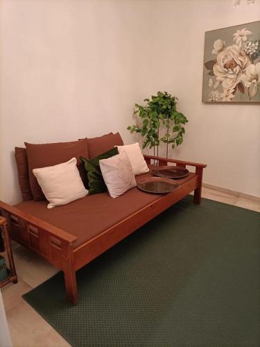 a wooden couch with pillows and a plant on it at Akademia House - Santarém in Santarém