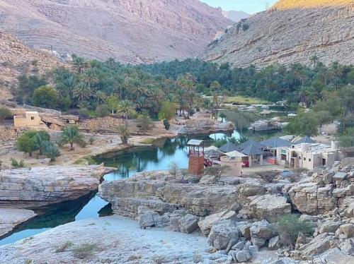 a river in the middle of a valley at Wadi Bani Khalid - Al Joud Green Hostel in Dawwah
