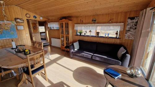 a living room with a couch and a table at Thingvellir Lake Cottage in Veiðilundur