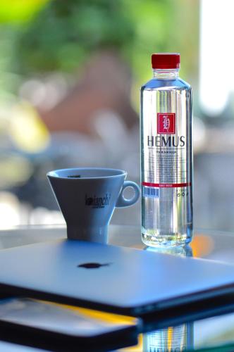 a bottle of water next to a cup on a table at Hemus Hotel - Vratza in Vratsa