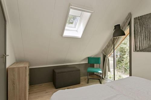 a bedroom with a bed and a chair and a window at Luxe, sfeervol en vrijstaand boshuis Chalet LaMast in Norg