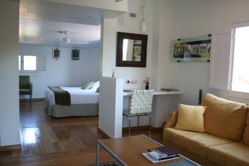 a living room with a bed and a couch at Hotel Boutique Mas Passamaner in La Selva del Camp