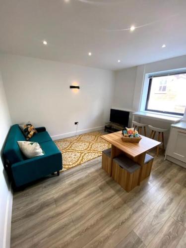 a living room with a blue couch and a coffee table at Modern City Centre Flat in Norwich