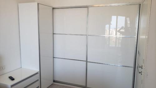 um armário branco com portas de vidro num quarto em Paradise Dream 3 Apartment in Vlora em Vlorë