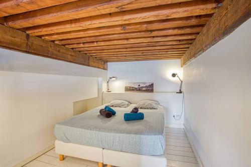 - une chambre avec un lit et un plafond en bois dans l'établissement Palace Opéra, studio de charme, à Lyon