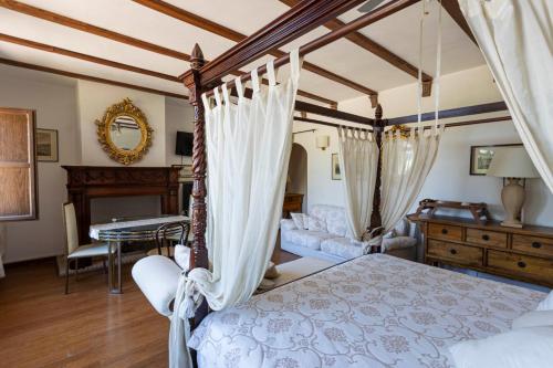 um quarto com uma cama de dossel e uma secretária em Prestigioso Casale Castello Alma em Ponticelli