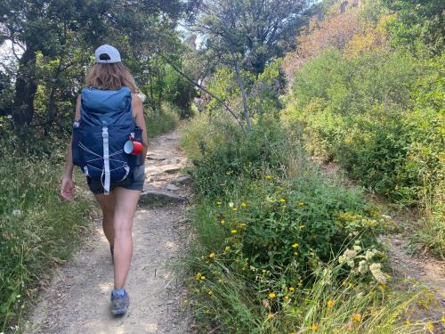 a woman walking down a trail with a backpack at Medieval Village B&B in Ne
