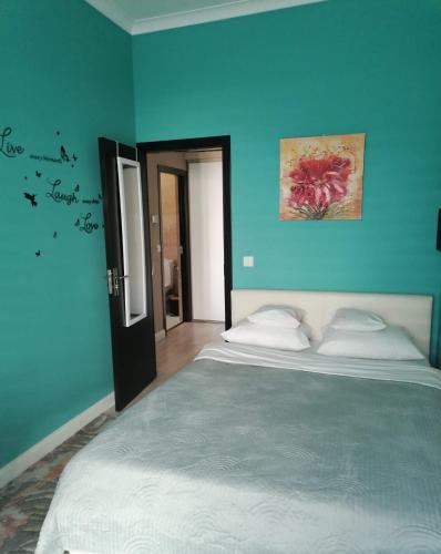 1 dormitorio con 1 cama grande y pared azul en Queency Apartament cu gradina și parcare gratuita, en Cluj-Napoca