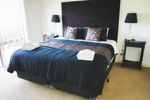 a bedroom with a large bed with two towels on it at Petit Verdot Cottage - A Vineyard Retreat in Barossa Valley in Rowland Flat