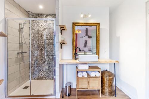 uma casa de banho com um lavatório e um chuveiro em Gîte le 11 em Le Merlerault