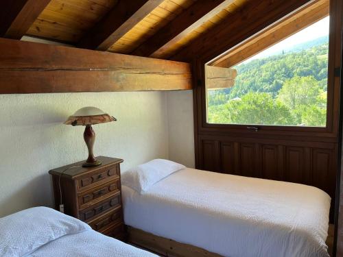 1 dormitorio con 2 camas y ventana en Casa Rina, en Gignod