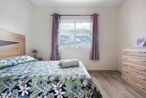 Schlafzimmer mit einem Bett und einem Fenster mit lila Vorhängen in der Unterkunft La casa de Amalia in Garachico