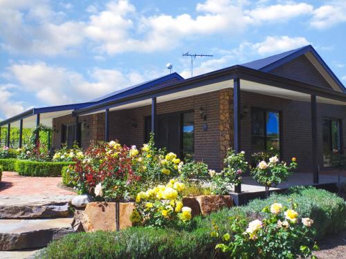 a house with some flowers in front of it at Shiraz Cottage - A Vineyard Retreat in Barossa Valley in Rowland Flat