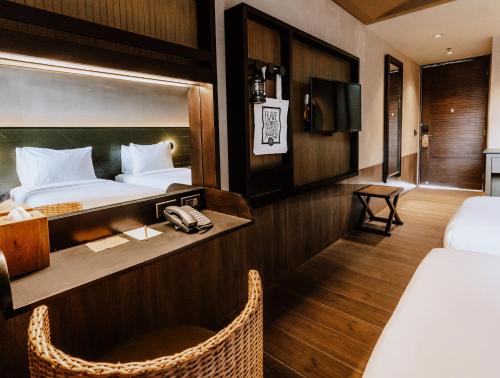 een hotelkamer met een bed en een bureau met een telefoon bij The Funny Lion - El Nido in El Nido