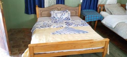a bedroom with a bed with a wooden frame at Rhino hillside in Sekenani