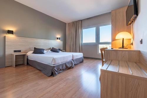 a hotel room with a bed and a large window at Hotel Air Penedès in Vilafranca del Penedès