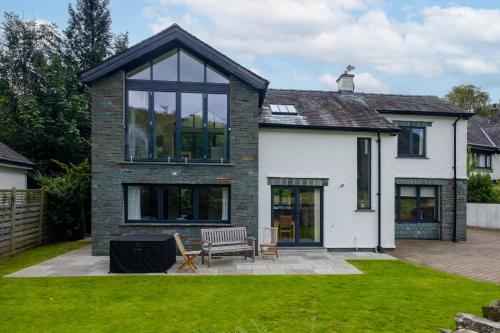 a white house with black windows and a lawn at The Old Police House in Grasmere