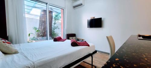 une chambre avec un lit blanc et une fenêtre dans l'établissement Oasis Marin 1 Studio Proche Mer Parking wifi, à Cagnes-sur-Mer