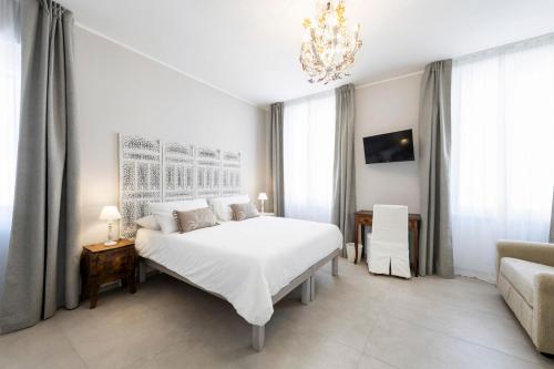 コルマーノにあるB&B De I Braviの白いベッドルーム(ベッド1台、ソファ付)