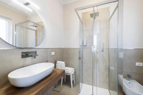 コルマーノにあるB&B De I Braviのバスルーム(白いバスタブ、ガラス張りのシャワー付)