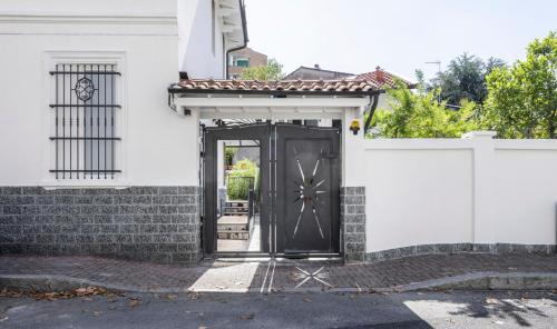 a black door on the side of a white house at B&B De I Bravi in Cormano