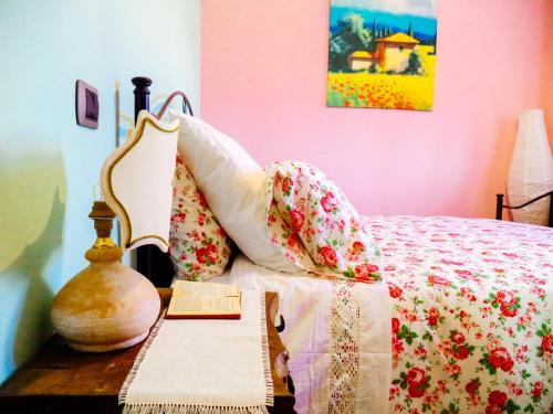 Un dormitorio con una cama y una mesa con un libro en Alba dei Due Soli B&B, en Nocera Umbra